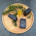 Savon Forêt noir sur une planche en bois avec une branche de pin et de l'huile