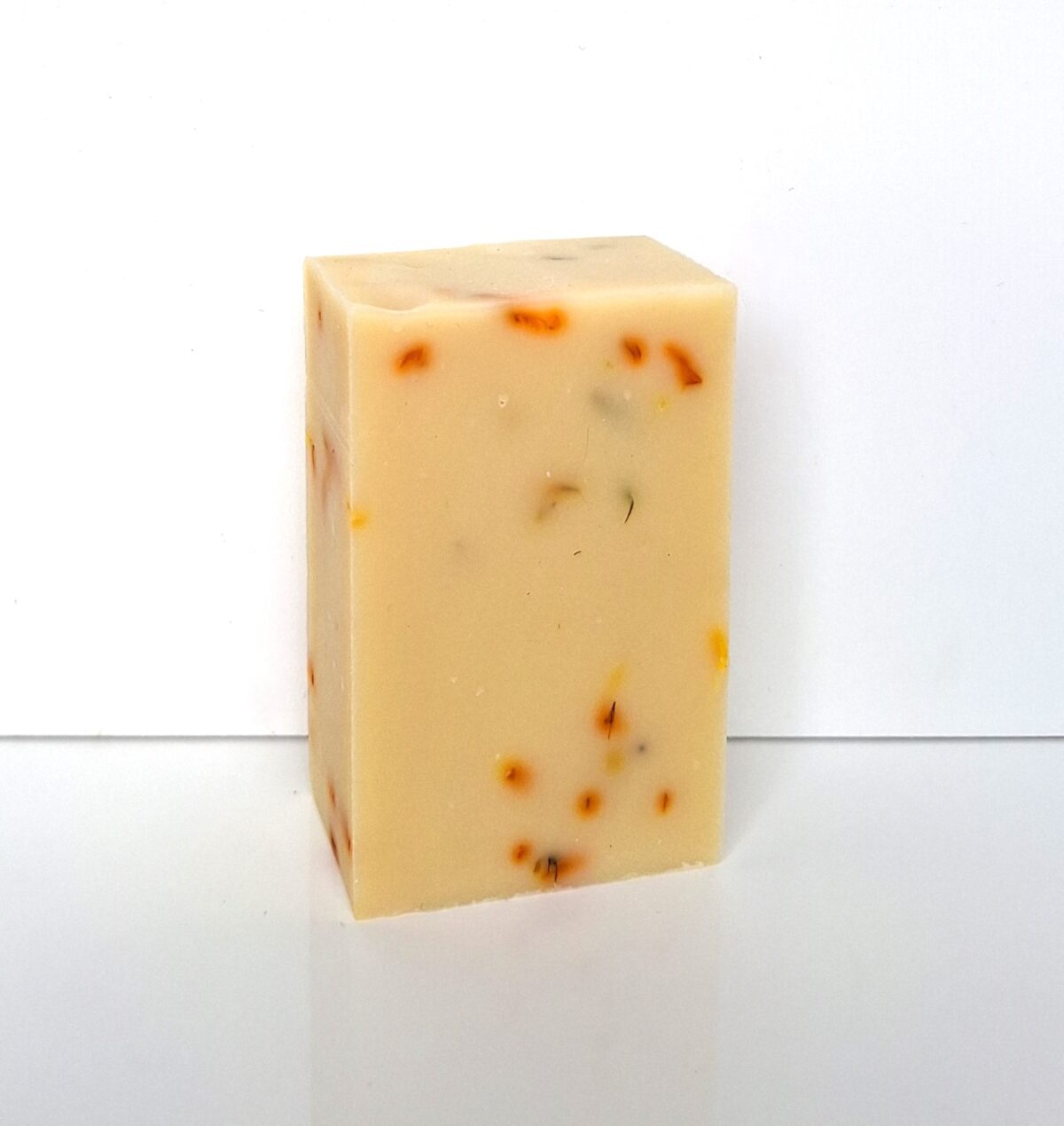 Savon naturel sans huiles essentielles au calendula, pain nu sur fond blanc.