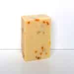 Savon naturel sans huiles essentielles au calendula, pain nu sur fond blanc.